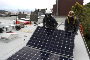 工人们在旧金山的一所房子里安装太阳能电池板，那里已经限制了新建筑中天然气的使用。