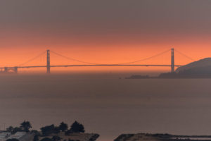 来自山火的烟雾在旧金山金门大桥后面形成了橙色的烟雾。