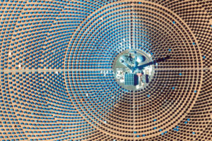 Ouarzazate太阳能电站是位于摩洛哥的多相太阳能特色，是世界上最大的集中太阳能发电厂，能量容量为510兆瓦。该设施的第三阶段，这里看到的820英尺的Noor III塔，使用7,400张Heliostat镜子聚焦太阳的能量，将熔盐加热至500-1022华氏度，产生产生电力的蒸汽。