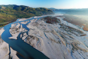 在阿尔巴尼亚，从未被人发现的Vjosa河在蜿蜒流向亚得里亚海的过程中，沿着河岸留下了巨大的砾石沉积物。