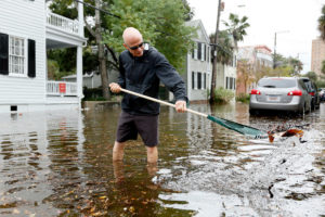 2015年10月，南卡罗莱纳查尔斯顿的一名居民正在清理下水道里的碎片。这座城市现在经历了一年50天的“晴天”洪水。