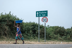 1月，乌干达阿尔伯特湖附近，一个女孩走过翠鸟油田的标志。