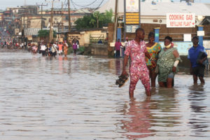 7月，尼日利亚拉各斯，居民们在被洪水淹没的Aboru社区的道路上跋涉。