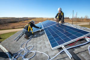 前油砂工人在亚伯达省威斯基温市附近的一个托儿中心安装太阳能电池板。