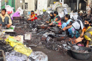 在印度巴特那，工人们拆除汽车电池，为铅回收做准备。