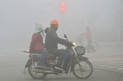 骑自行车的人在2017年1月在中国山东省潍坊市的沉重烟雾骑行。 