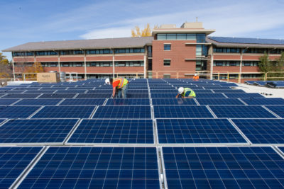 承包商在科罗拉多州立大学的布雷登大厅顶上安装太阳能电池板。