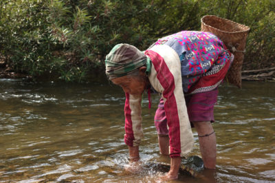 一位卡伦妇女在公园里用传统的渔网捕鱼。